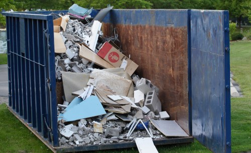 A skip being loaded with construction debris in Aldgate